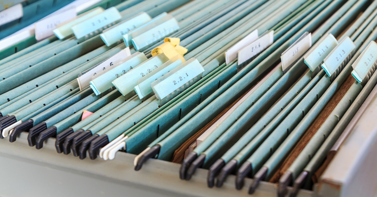 Multiple file folders organized in a filing cabinet. Each folder has a tab with three numbers on it.