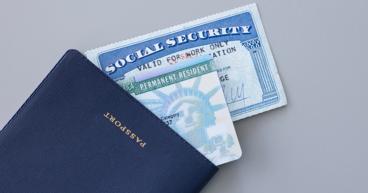 A blue passport holder, Social Security card, and permanent resident green card arranged on a white background.