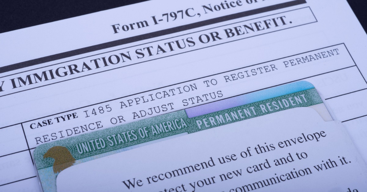 A notice of action form with a permanent resident card tucked into an envelope on top of the document.