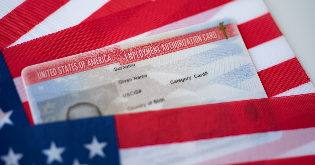 Two American flags layered on top of one another; in between them is a United States Employment Authorization Card.