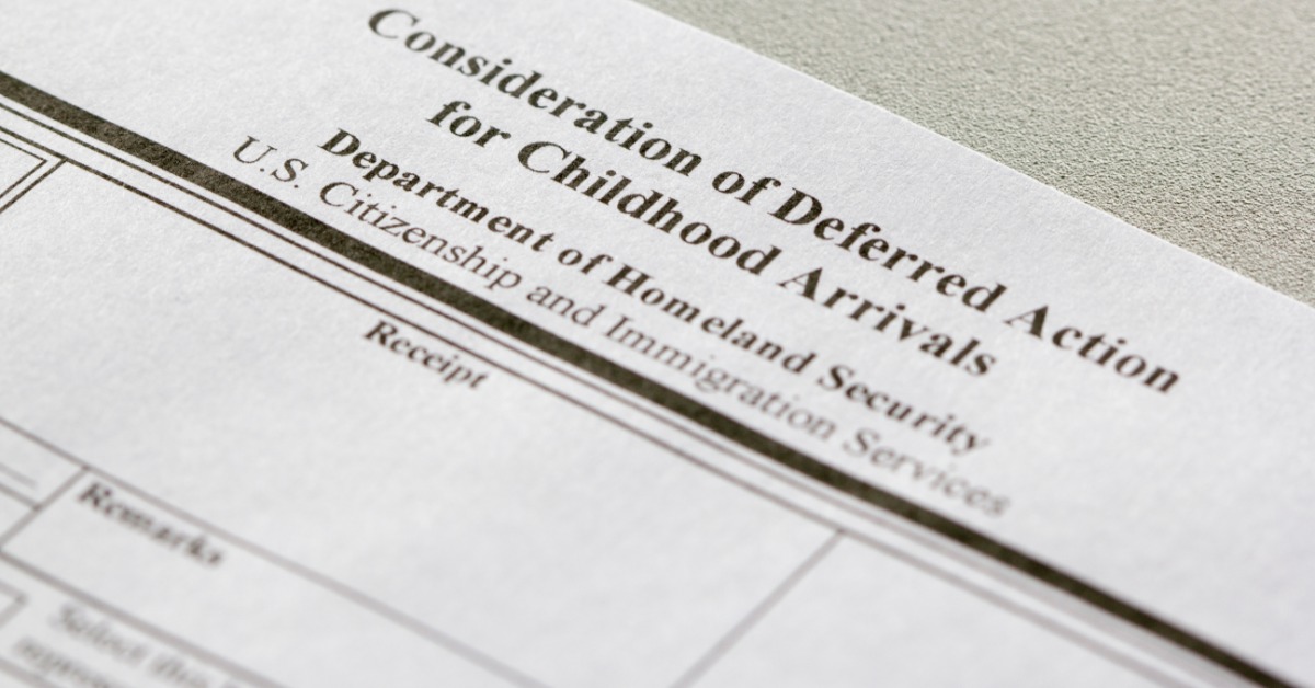 a close-up view of a USCIS Form I-821D document on a flat surface with printed text and blank fields visible.