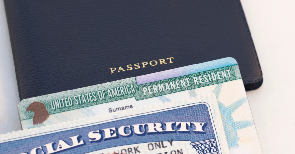 a passport, permanent resident card, and Social Security card arranged together on a white background.